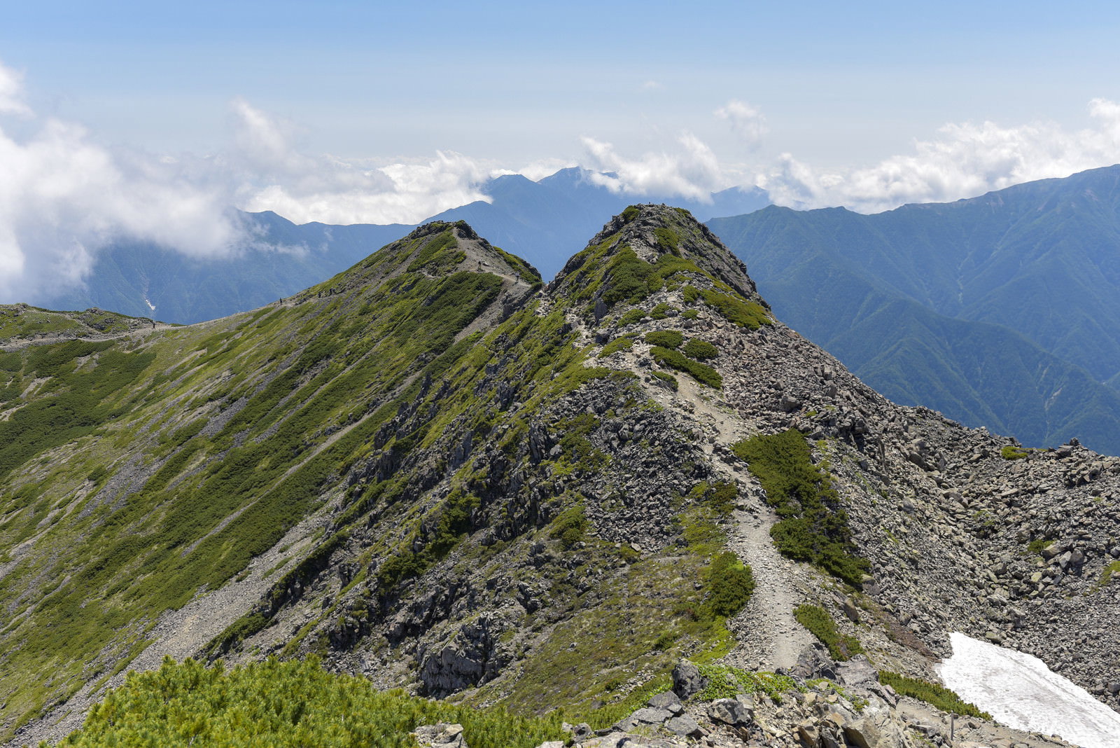 仙丈ヶ岳の稜線を歩く登山道と背景の南アルプスの山々