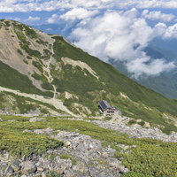 仙丈ヶ岳の稜線から見下ろす眼下の山小屋と登山道の写真