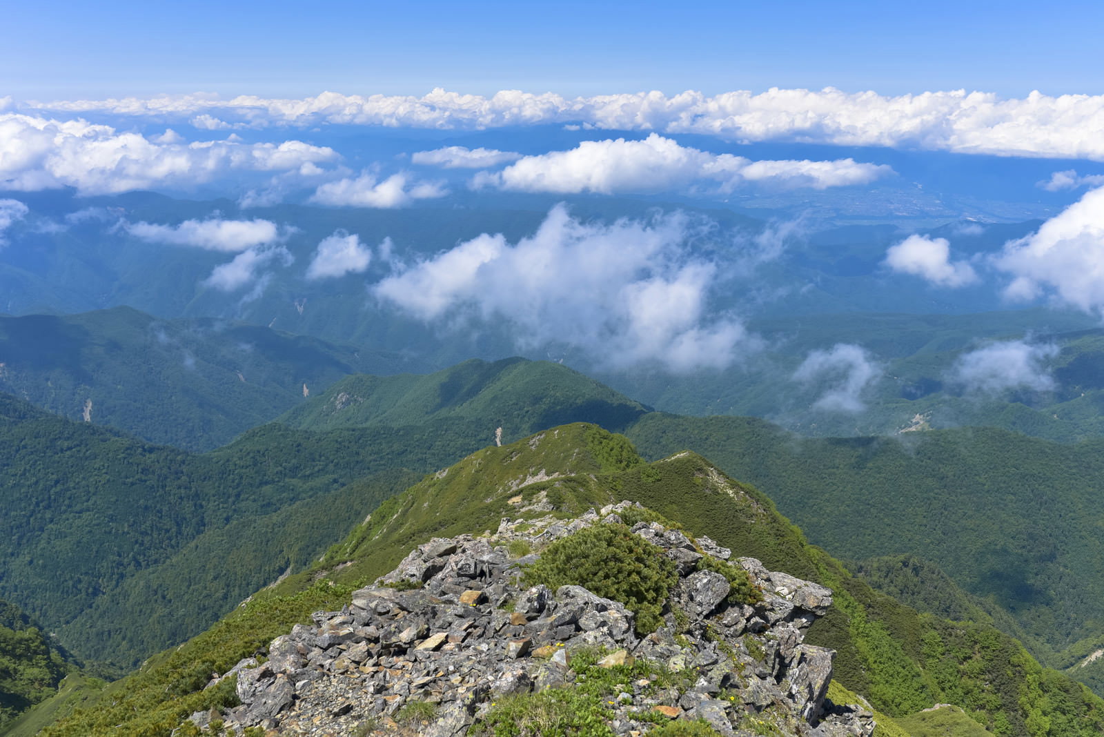 大仙丈岳の岩場から伊那方面の山々を望む景色、雲海が流れる