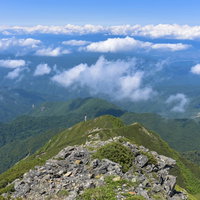 大仙丈岳の岩場から見る伊那方面の景色と南アルプスの山々の写真