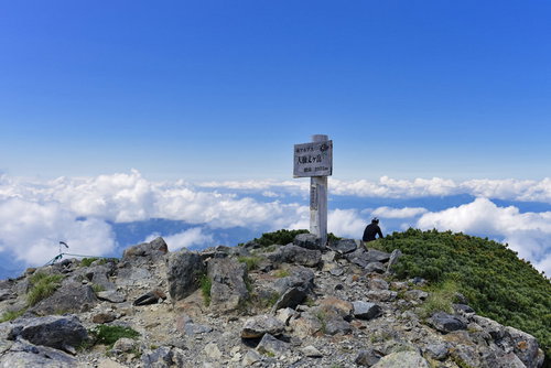 大仙丈岳山頂に佇む登山者と眼下の雲