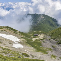 雲が迫りくる仙丈ヶ岳の山小屋｜南アルプスの高山風景の写真