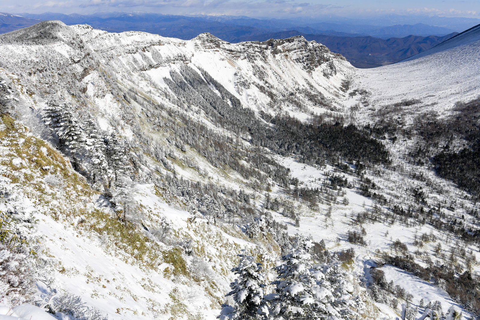 雪化粧した浅間山の斜面、残雪と岩肌が織りなす山岳風景