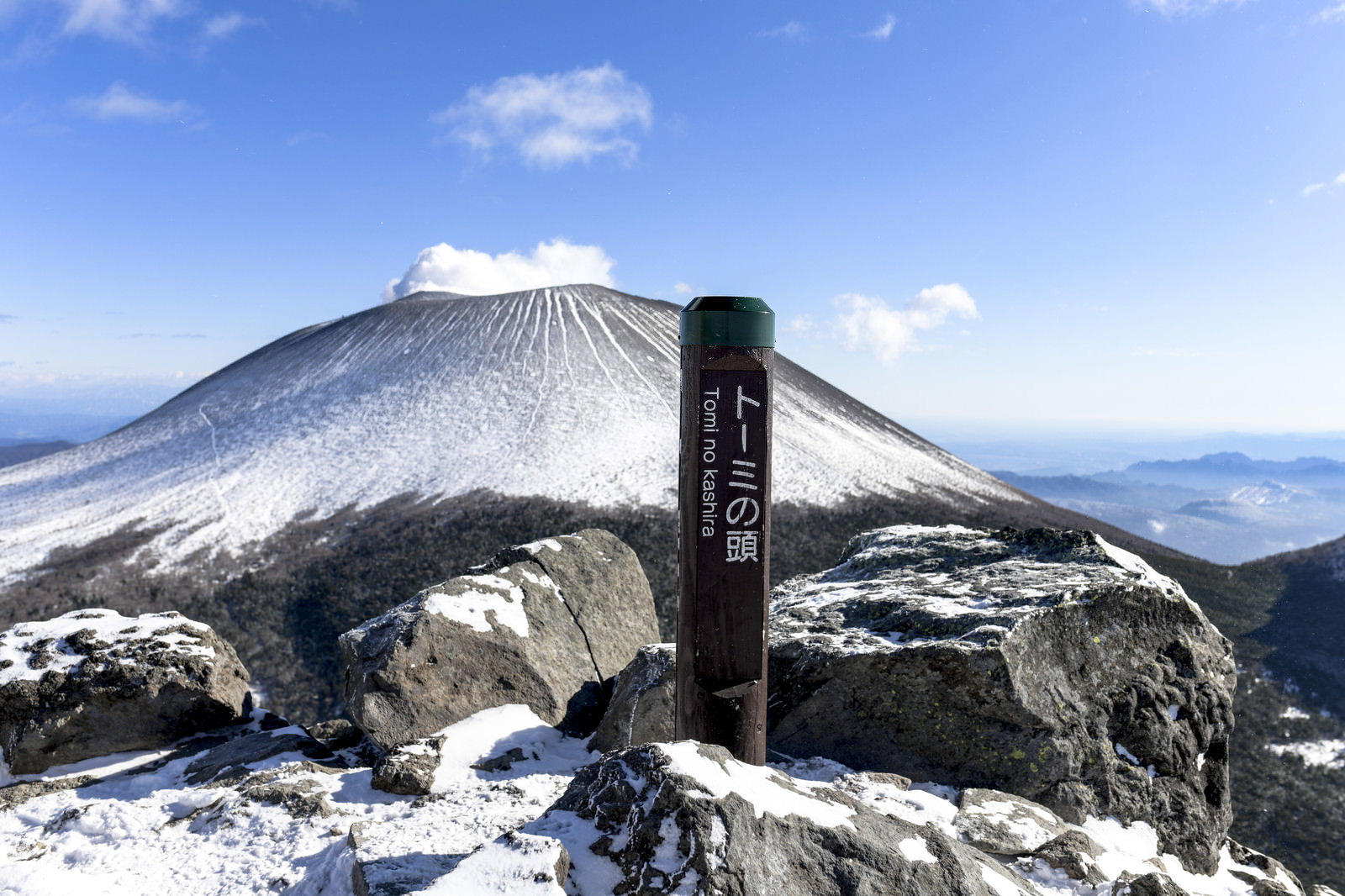 トーミの頭山頂から眺める雪化粧した浅間山と青空、手前に山頂標識