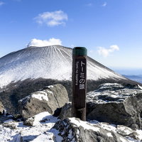 トーミの頭から見る雪化粧した浅間山と山頂標識の写真