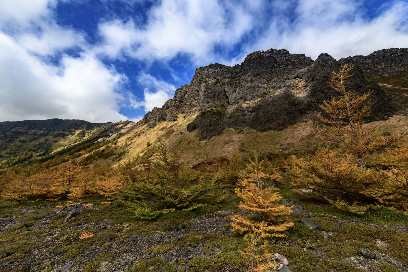 青空をバックに聳える浅間山の黒斑山絶壁と手前に広がる紅葉の山肌