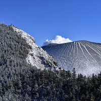 雪化粧した黒斑山へ続く稜線と浅間山の遠景の写真