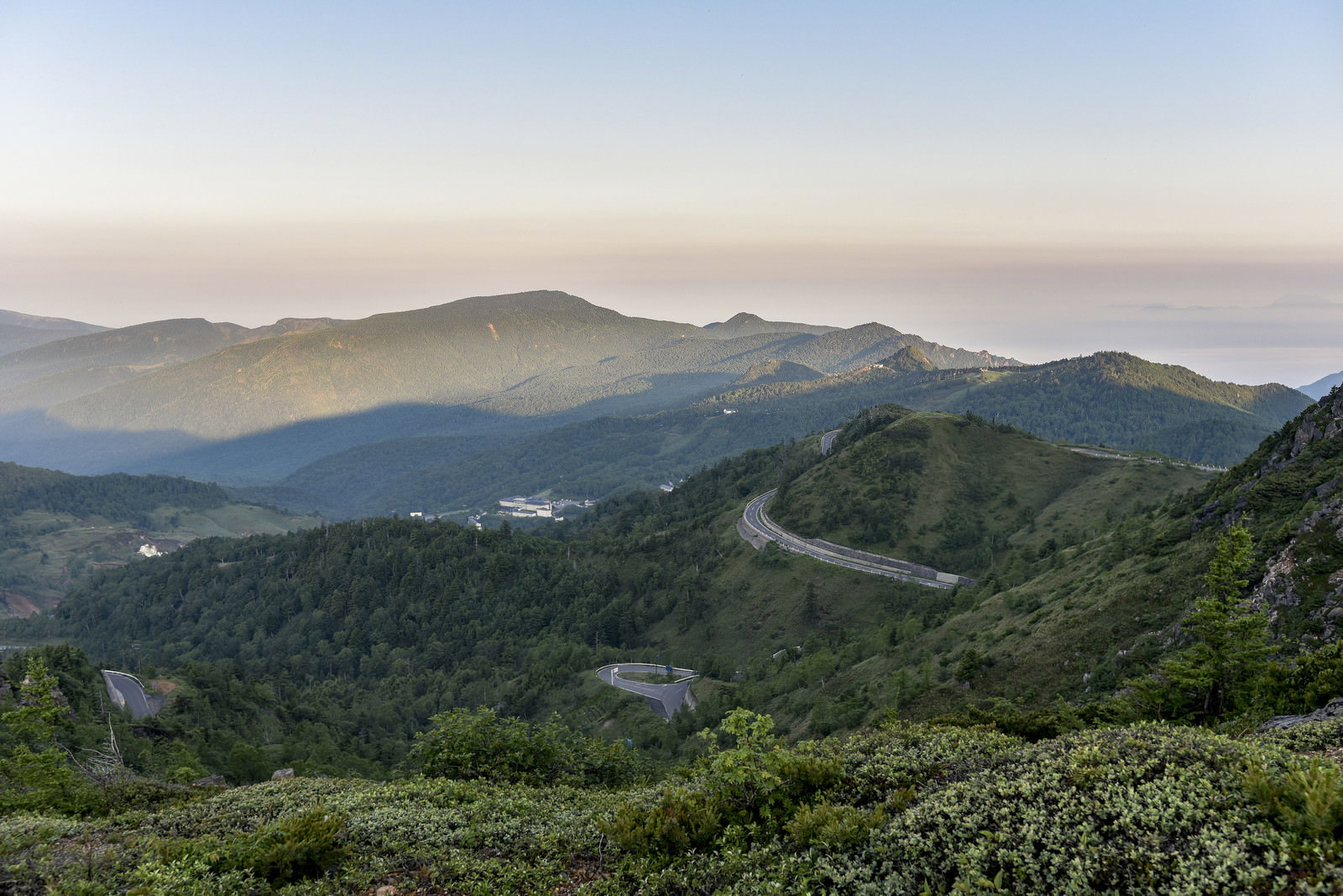 早朝の草津白根山につながるヘアピンカーブの山道