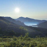 朝焼けに光る草津白根山湯釜の写真