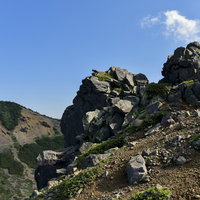 草津白根山の本白根山にそびえる岩石群と青空の写真