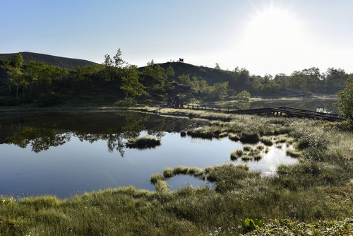 草津白根山の弓池、湖面に空と山々を映す火口湖