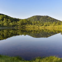 鏡面反射が鮮やかな弓池の朝（草津白根山）の写真