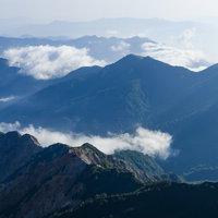低い雲を纏った日本百名山・白山の山々と青空の風景の写真