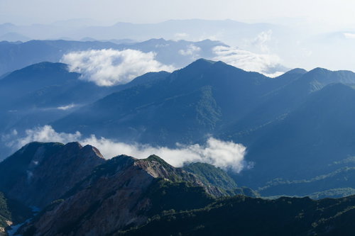 低い雲を纏った日本百名山・白山の山々と青空の風景