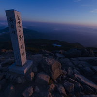 夕日で赤く焼けた白山御前峰の山頂碑、日本百名山の絶景の写真