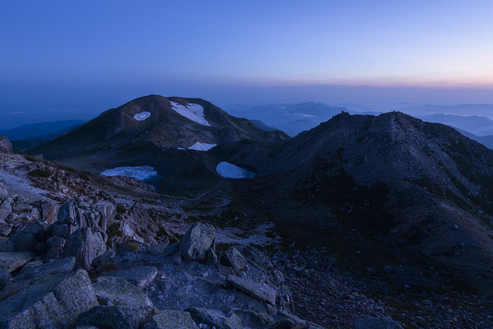 朝焼けの空の下、白山の大汝峰と剣ヶ峰の稜線が見える山岳風景