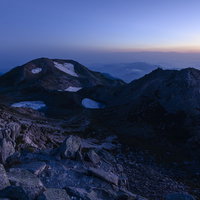 夜明け前の白山山頂、薄紫から青へ変わる空と雪の山並みの写真