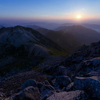白山の御前峰から見る朝日と影となった剣ヶ峰の写真