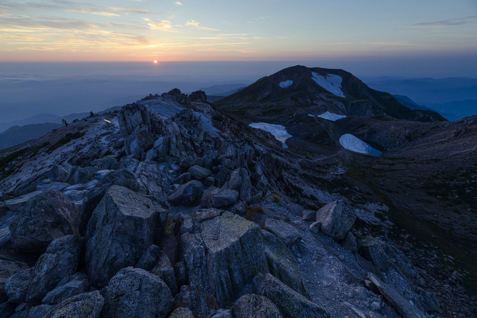 白山・御前峰の岩稜越しに沈む夕日