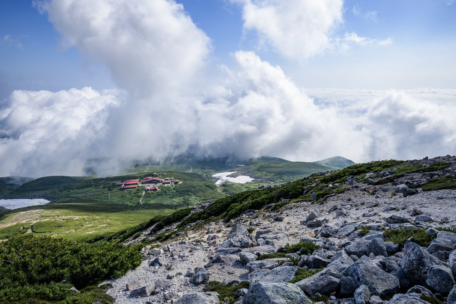 御前峰登山道から見た白山室堂小屋の風景、緑の草原と雲海