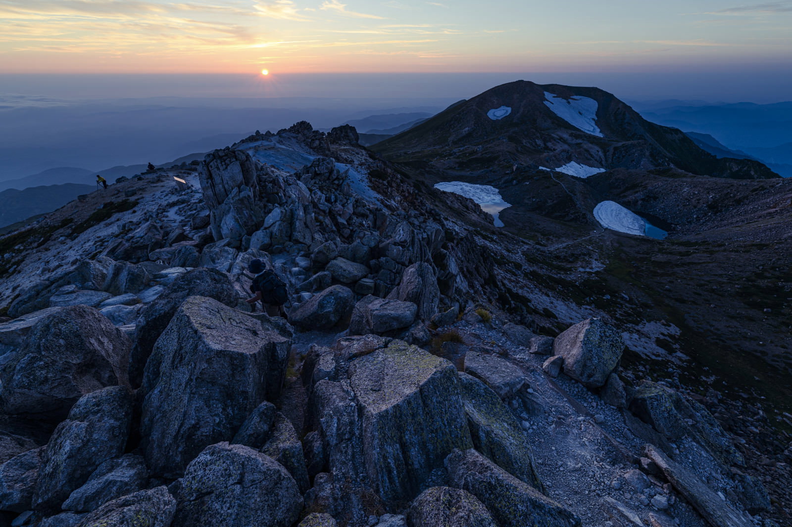 夕焼け空の下に広がる白山御前峰の岩場の稜線