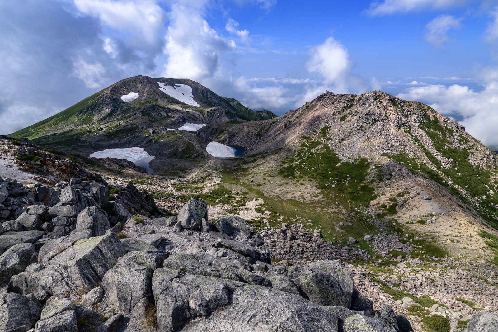青空の下に聳える白山の大汝峰と剣ヶ峰の山岳風景
