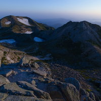 朝焼けに染まる白山の御前峰から見る剣ヶ峰と大汝峰の写真