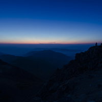 白山山頂で夜明けを待つ登山者たちのシルエットの写真