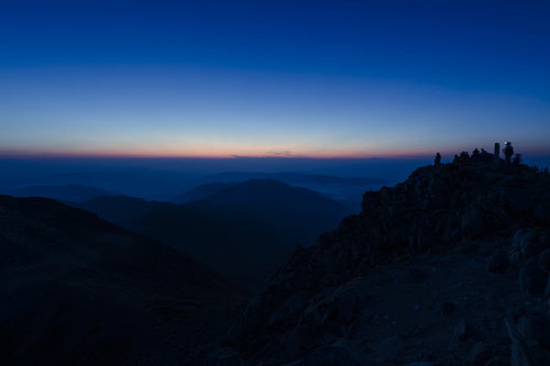 白山山頂で夜明けを待つ登山者たちのシルエット