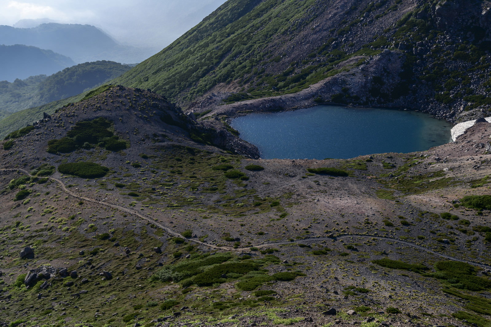 白山の翠ヶ池脇を通る登山道と緑の湖面が広がる山岳風景