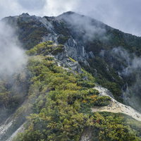 雲に包まれる鳳凰山の稜線と登山道（鳳凰三山）の写真