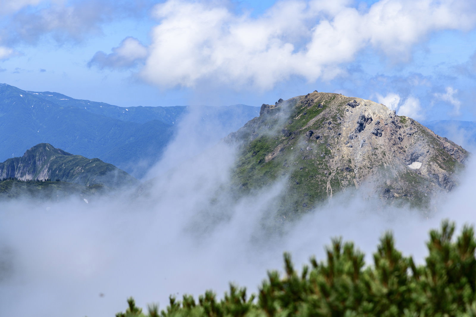雲海に包まれた新潟焼山と雨飾山の山並みを火打山山頂から撮影した風景