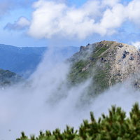 火打山山頂から望む新潟焼山と雨飾山の山並みの写真