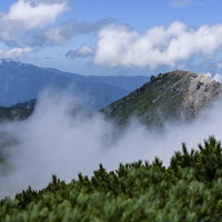 火打山から見える焼山と雲海に浮かぶ白い雲の写真