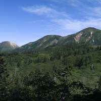 青空の下に連なる火打山と新潟焦山の山岳風景の写真