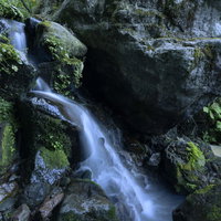 火打山の岩肌を流れる渓流と白い飛沫の写真