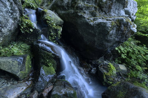火打山の岩肌を流れる渓流と白い飛沫