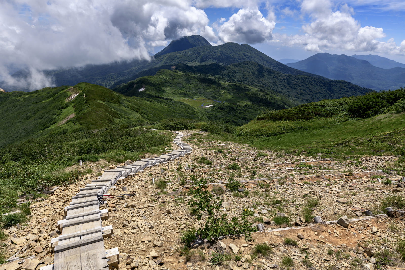 火打山から見た妙高山の山景色、木道が続く登山道と青空