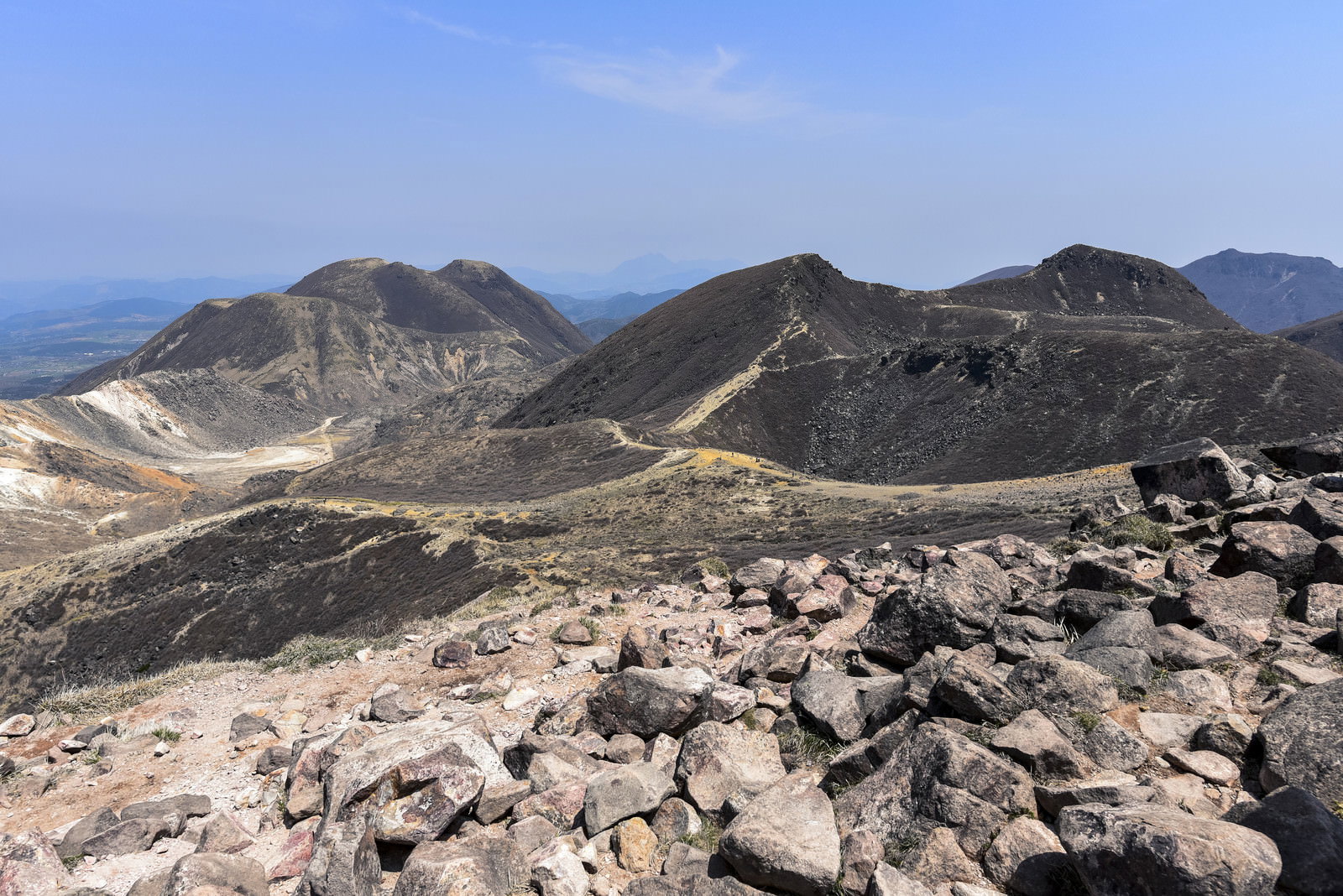 久住山、三俣山、中岳の山々と手前に岩が点在する火山荒野の風景