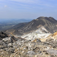 久住山と三俣山、麓に広がる街並みを見下ろす景観の写真
