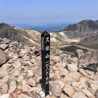 大分県の久住山山頂に立つ黒い山頂標と碑、九重連山の写真