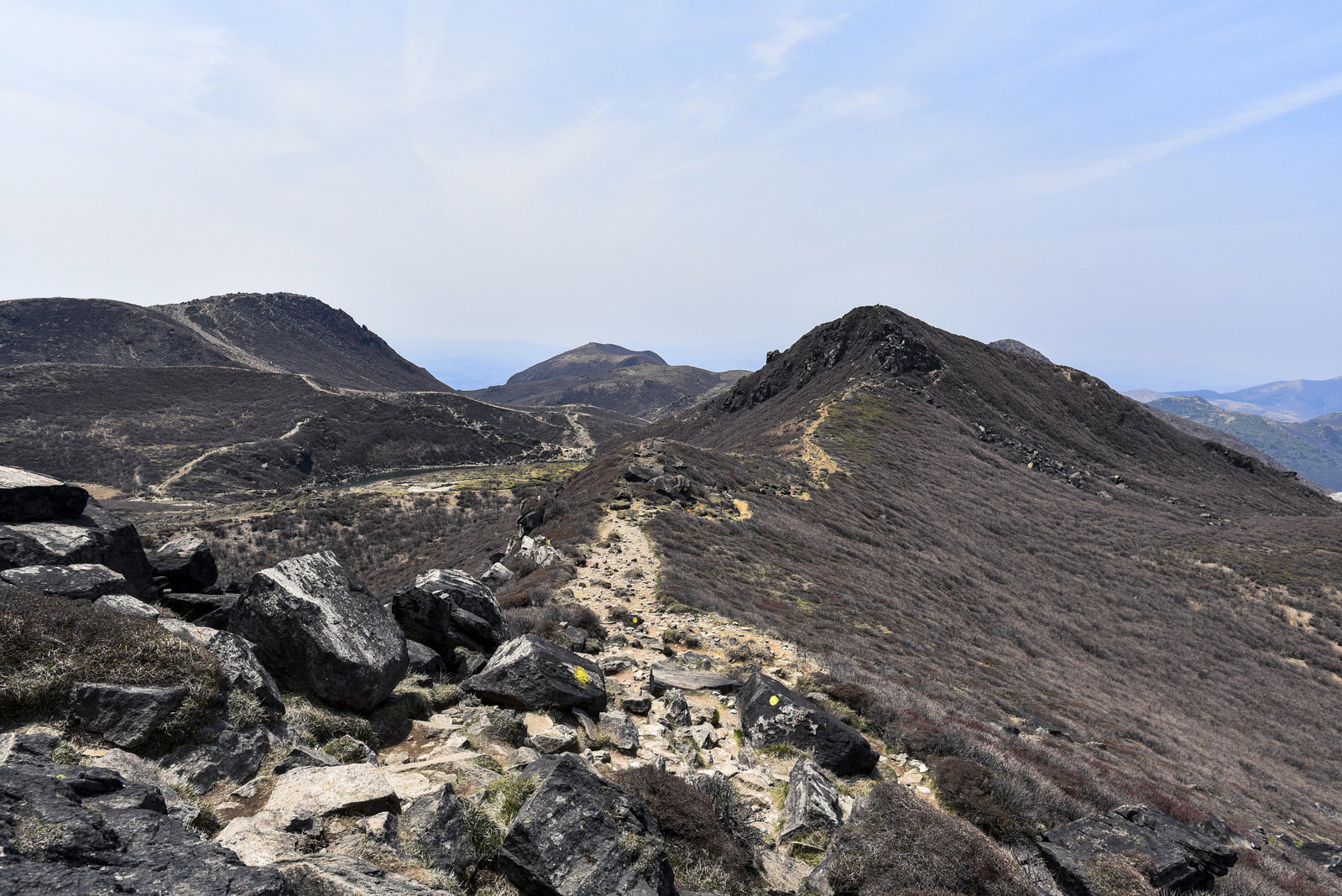 久住山星生山方面の荒々しい火山地形と岩場の登山道が続く山岳風景