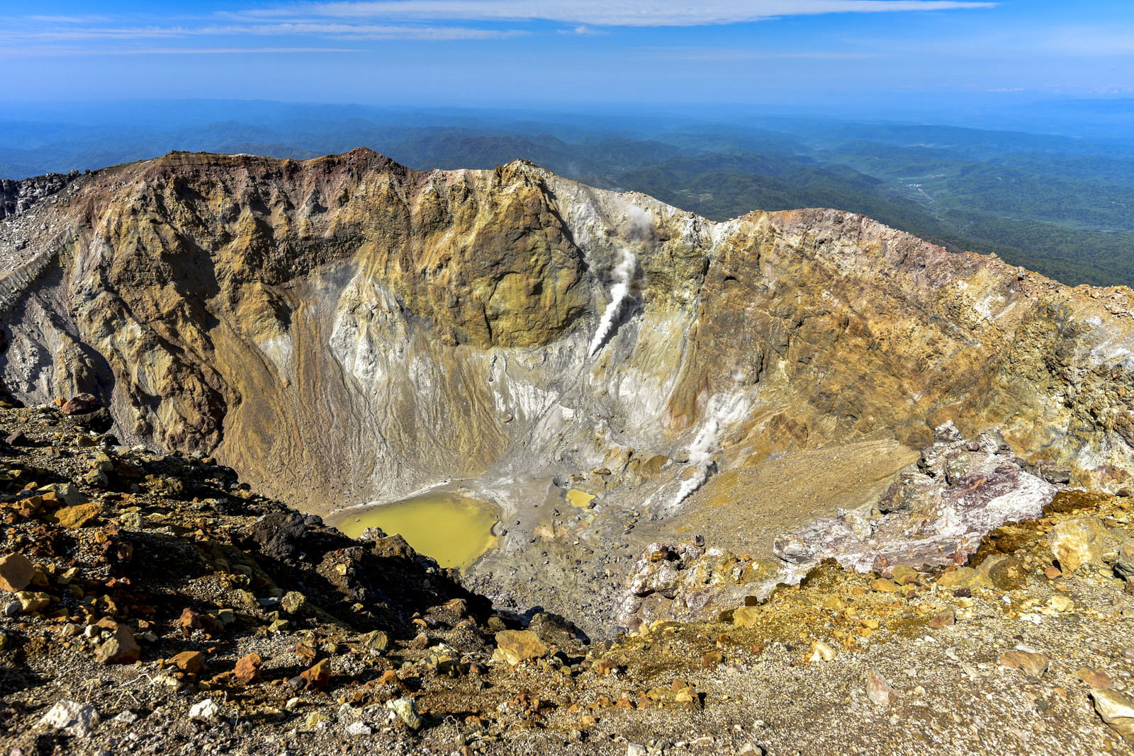 雌阿寒岳の山頂から見下ろした巨大な火口と緑色の火口湖