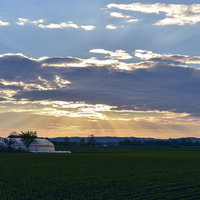 朝焼けに染まる十勝の農地と雌阿寒岳の朝日風景の写真