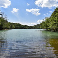 正午の青空に映るオンネトー（雌阿寒岳）の静寂な湖面風景の写真