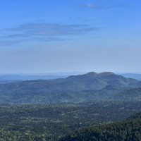 道東の原生林が広がる樹林の景色、雌阿寒岳の山々を望むの写真