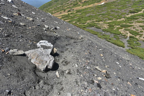 雌阿寒岳・阿寒富士中腹の砂礫登山道を行く登山者の風景