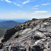 雌阿寒岳の阿寒富士山頂に広がる溶岩が固まった岩場の写真