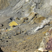雌阿寒岳の活火山お釜の底の岩石と硫黄成分の写真