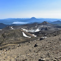 雌阿寒岳の山頂から望む阿寒湖方面の景観と火山地形の写真